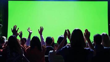 Happy viewers crowd clapping hands looking at green chroma key cinema screen expressing admiration. Business. video