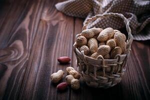 Peanuts in shell on wooden background photo