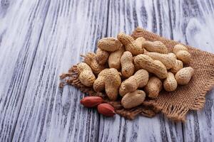 Peanuts in shell on wooden background photo