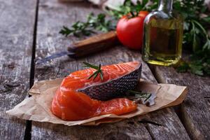 Raw salmon fillet on wooden background photo