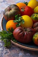 Different sort of tomato on concrete background photo