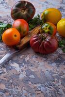 Different sort of tomato on concrete background photo