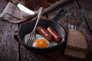 Fried eggs with sausages in a pan photo