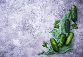 Fresh cucumbers on concrete background photo