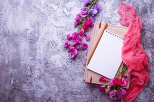 Open empty notebook and flowers. photo