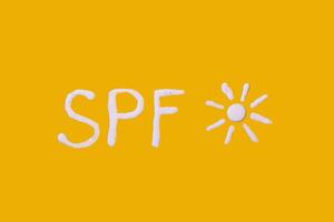 Sunscreen SPF cream on yellow background photo