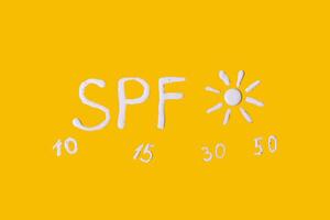 Sunscreen SPF cream on yellow background photo