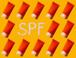 Sunscreen SPF sunblock cream on yellow background photo