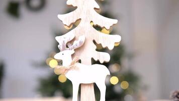 Wooden deer and a Christmas tree against the background of a New Year's garland. video