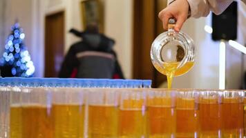 The waiter pours apple juice into a glass on the buffet line video