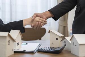 Estate agent shaking hands with customer after contract signature photo
