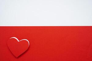 Red paper hearts isolated on red background On the bottom left there is an empty space photo