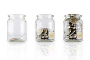 Glass bottles with growing coins are like a diagram of savings ideas. White isolated background photo