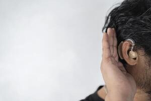 A man in his late 40s began to have difficulty hearing and had to use a hearing aid. photo