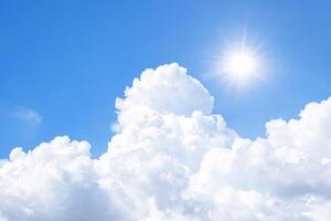 The sky is full of clouds floating around, both small and large, the sun is shining brightly photo