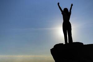 Traveler looking and enjoying sunrise on peak of mountain. photo