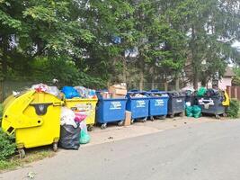 Dumpsters being full with garbage. Trash can overflowing litter pollution photo