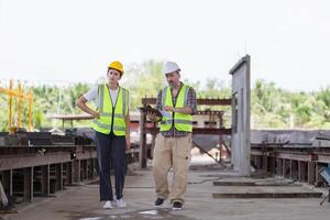 capataz trabajador equipo comprobación proyecto a el prefabricado hormigón fábrica sitio, ingenieros trabajando en construcción sitio foto