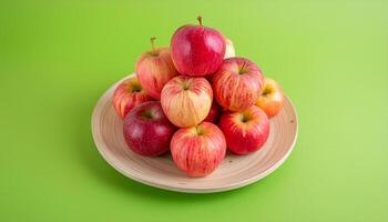 pile of apples on a plate with green background photo