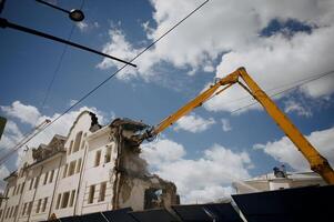 Excavator for demolition of buildings with a hydraulic crusher. The concept of demolition of buildings using excavators. photo