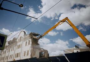 Excavator for demolition of buildings with a hydraulic crusher. The concept of demolition of buildings using excavators. photo