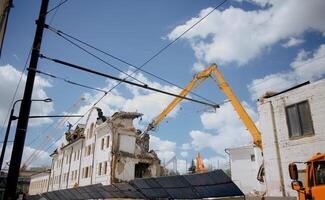 Excavator for demolition of buildings with a hydraulic crusher. The concept of demolition of buildings using excavators. photo