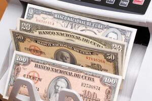 Old Cuban Pesos in the counting machine photo
