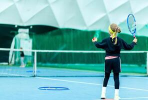 Child Preparing to Serve on Tennis Court. Minsk, Belarus - October 18, 2021 photo