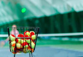 Basket of Beginner Tennis Balls on Court photo