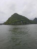 This captivating photograph captures a small, secluded island nestled in the vast expanse of the ocean. photo