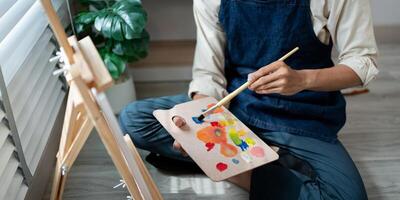 Artist Painting on Canvas in Studio with Colorful Palette and Natural Light from Window photo