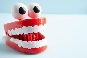 Tooth funny toy denture red color jaw and eye on white background with copy space. photo