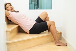 Asian lady fall down the stairs and pain at hip and waist because slippery surfaces. photo