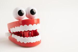Tooth funny toy denture red color jaw and eye on whtie background. photo