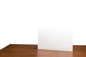 Blank menu frame label mockup in restaurant bar stand for booklet with acrylic white sheet paper tent card on wooden table. White isolated background photo
