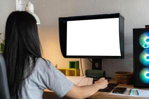 Mockup image of a woman using desktop computer with blank screen on wooden table. Female writer keyboarding photo