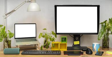 Blank white computer monitors on light wooden table with keyboard, mockup. Contemporary office and laptop photo