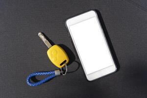 Car key. Auto remote control, flip key on a mobile phone, black background. Vehicle engine start, doors and trunk open and close. photo