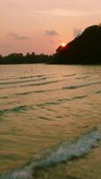 aéreo zangão Visão do a tropical de praia com branco areia e Palma árvore às a pôr do sol video