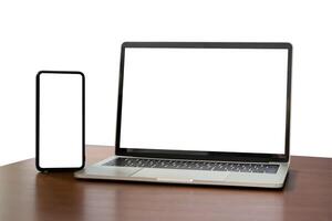 Blank screen notebook, laptop and mobile phone on isolated wooden table background with clipping path. Front view. photo