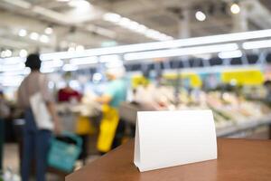 White framed sign on the table in the supermarket mockup. mini sign layout for menu, sign, label, text. photo