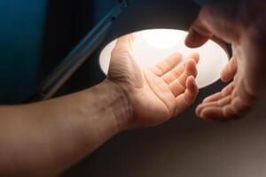 man turning into a light bulb LED at the desk lamp, electric change warm light at home. photo
