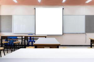 Projector screen canvas in modern conference room with big windows. Side view.Empty classroom or presentation room interior with desks, foreground table photo