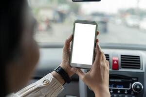 Happy couple using showing smartphone with empty screen, using mobile phone to look through navigation map during car trip photo