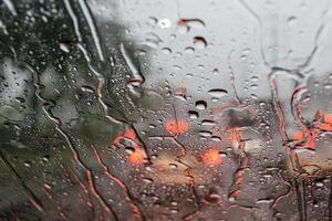 Selective focus to rain droplet with motion blurry wiper on windshield. Windshield wipers from inside of car photo