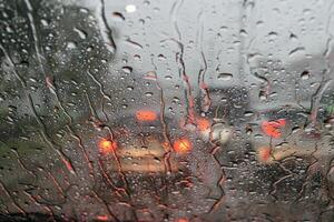 Windshield wipers from inside of car, season rain,filter color effect. Selective focus to rain droplet photo
