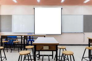 Projector screen canvas in modern conference room with big windows. Side view.Empty classroom or presentation room interior with desks photo