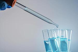 Laboratory test tube background. Covid-19 corona virus pandemic crisis. Glass pipette fluid drop. Global disease problem. Vaccine research science texture. photo