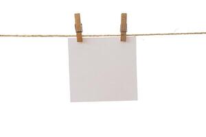 Empty color paper sheets for notes, frames that hang on a rope with clothespins and isolated on white. photo