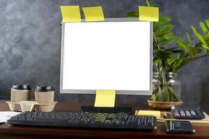 Computer monitor with white blank screen on the business desk with wireless mouse, keyboard at home office over black wall background. photo